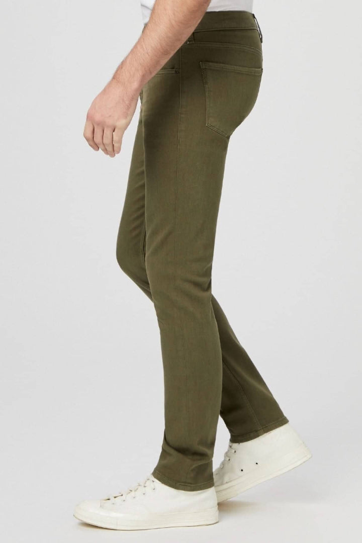 Jean Courtyard slim vert armée, moderne avec une coupe confortable, portée avec des sneakers blanches.