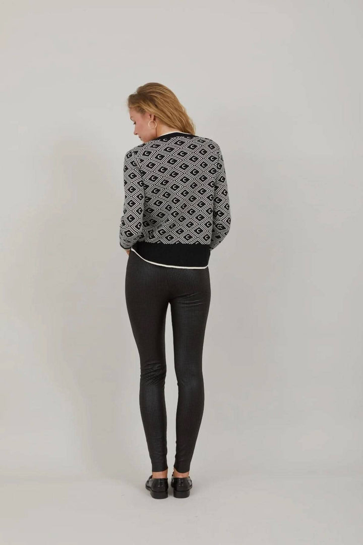 Femme de dos portant un legging noir et un haut à motifs géométriques, idéal pour un look chic décontracté.