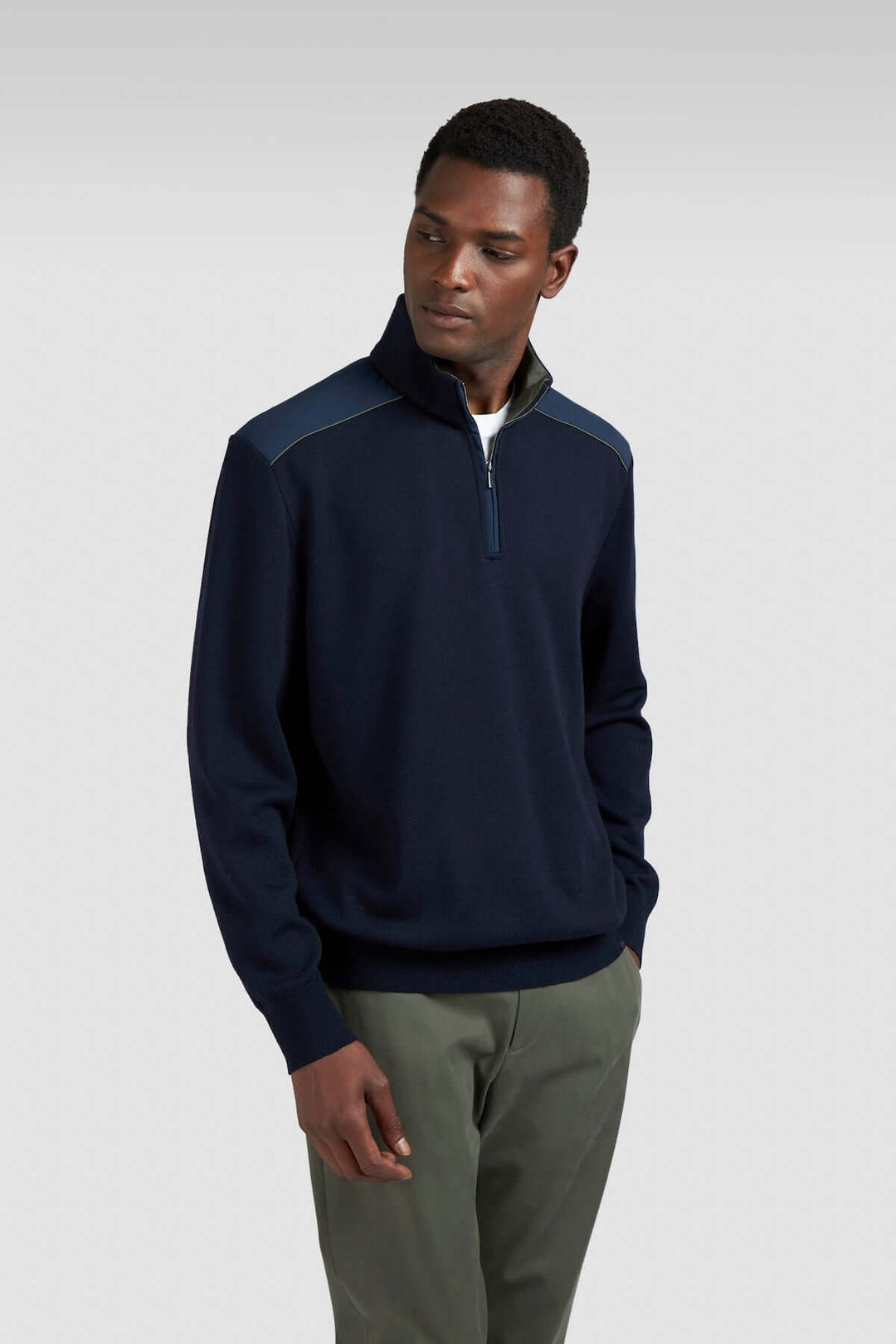 Chandail en tricot à col zippé, détails contrastants, style décontracté et moderne, porté par un homme.