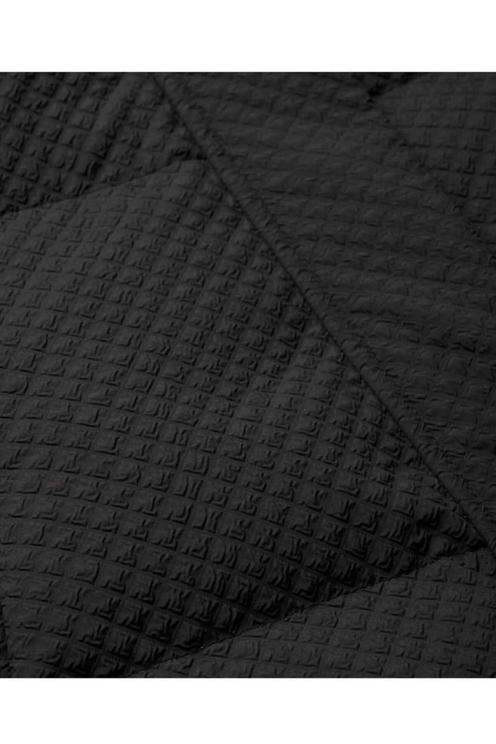 Gilet matelassé noir Tahani, texture et détail du tissu matelassé.