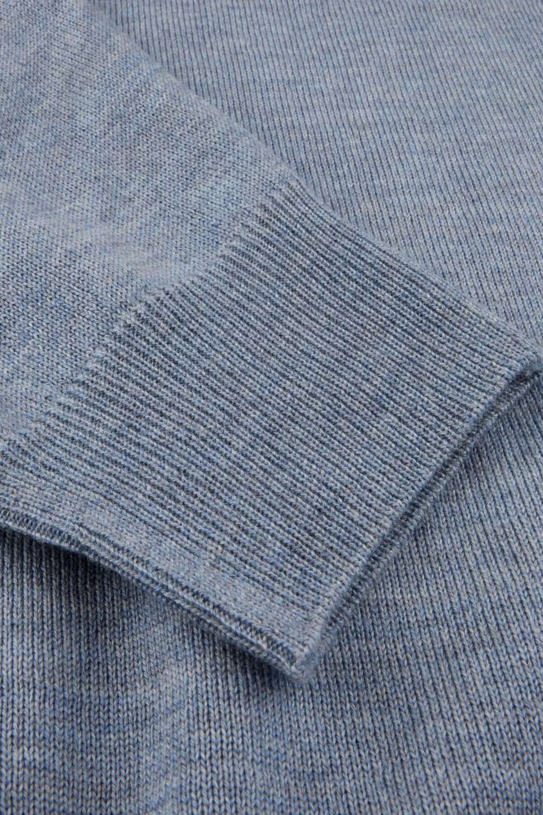 Détail chandail col rond en laine mérinos avec coudes contrastants, texture finement tricotée avec finitions côtelées.