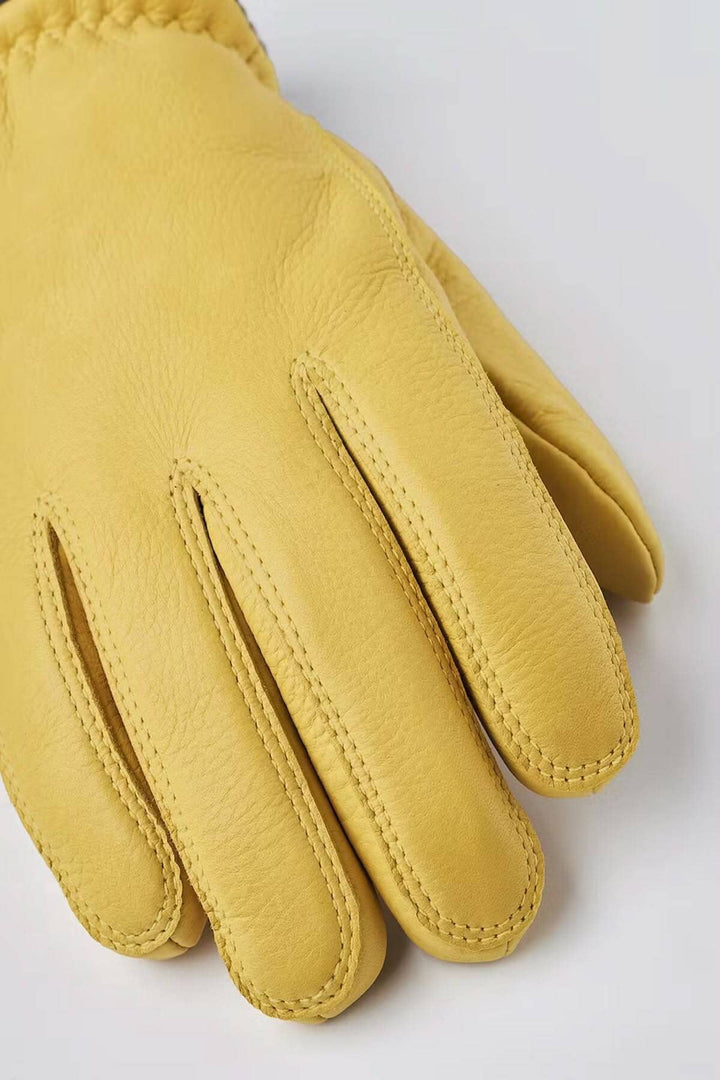 Gant de cuir jaune en peau de cerf avec coupe élégante et couture raffinée, idéal pour l'hiver.
