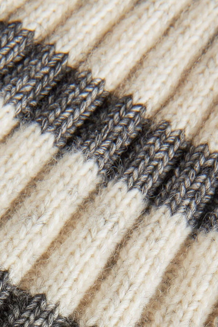 Bonnet rayé en laine et coton, couleurs neutres, texture tricotée douce et chaleureuse.