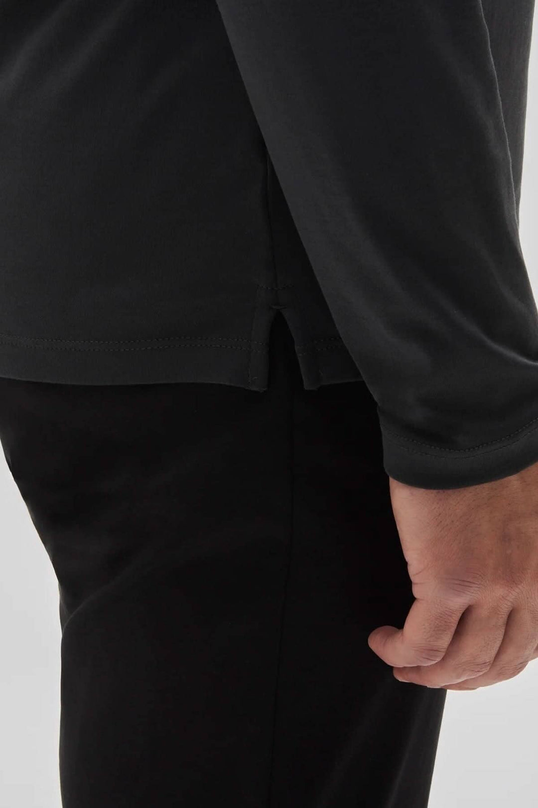 Col roulé de coton Georgia, vue détaillée du bas de la manche et du vêtement noir, mettant en avant le confort et la qualité.