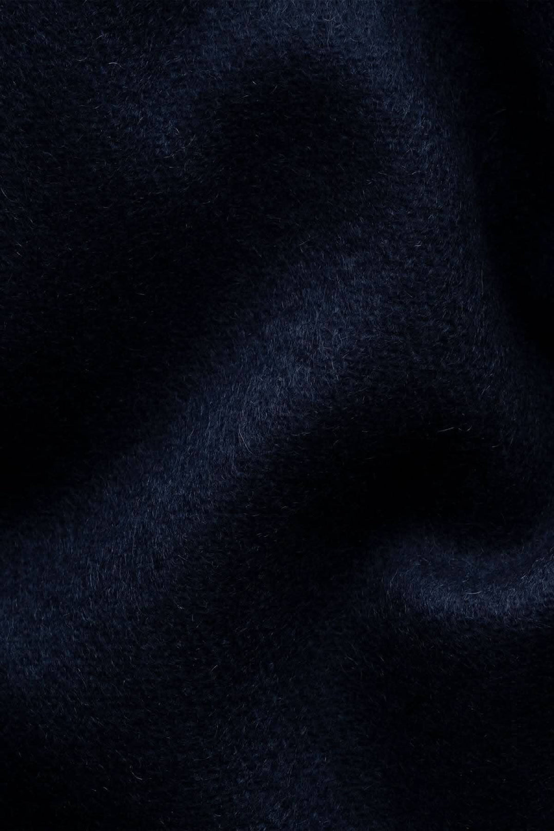 Texture d'un foulard en cachemire bleu marine, ultra-doux et luxueux, parfait pour les journées fraîches.