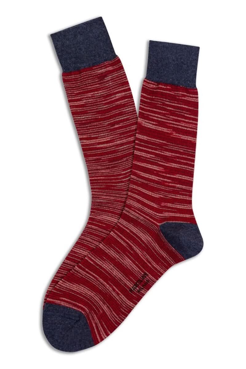 Bas en coton Pima rouge avec rayures abstraites et revers bleu, doux et chauds pour les saisons fraîches.