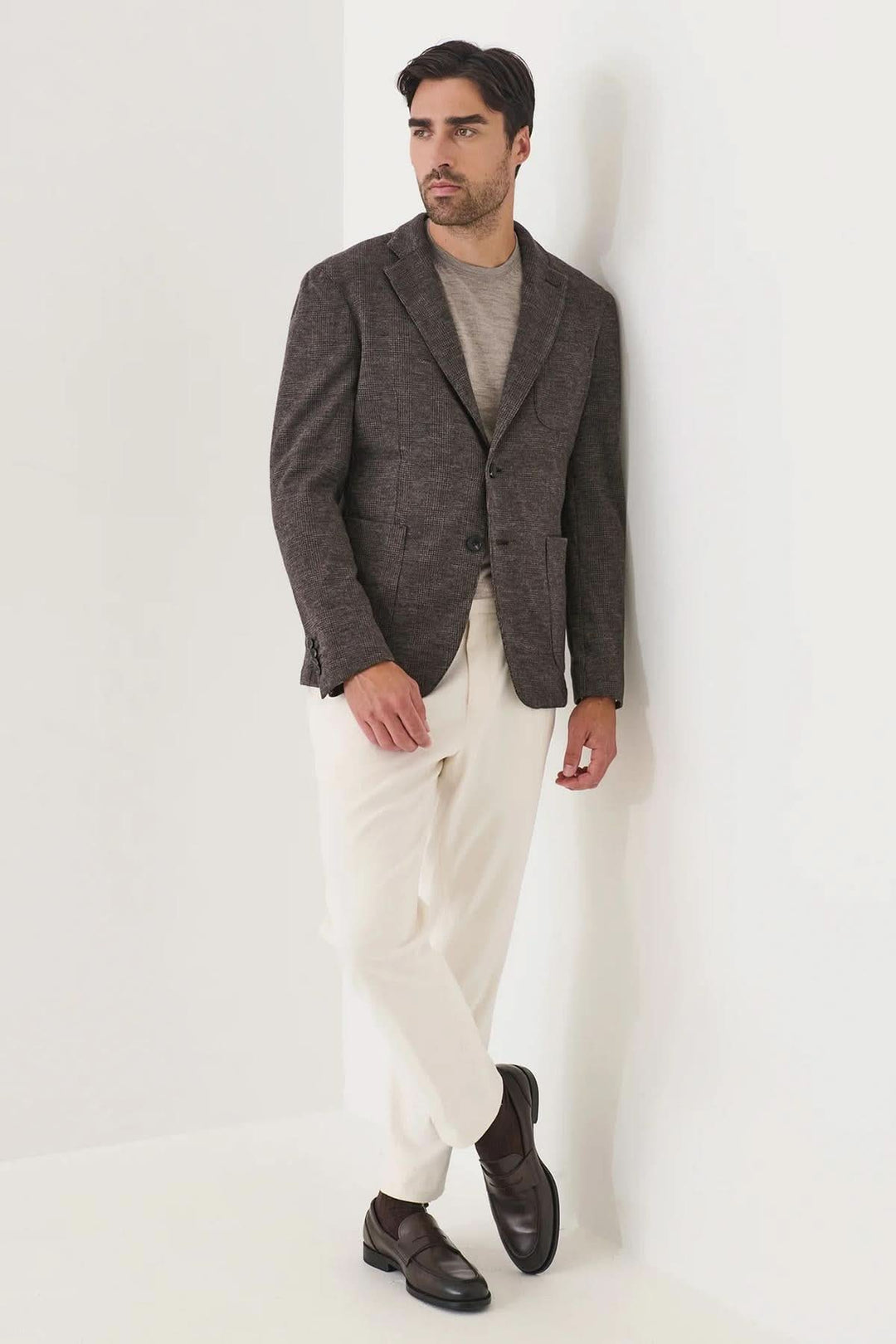 Homme portant un blazer à deux boutons en laine à carreaux, style moderne et élégant, parfait pour un look sophistiqué et décontracté.