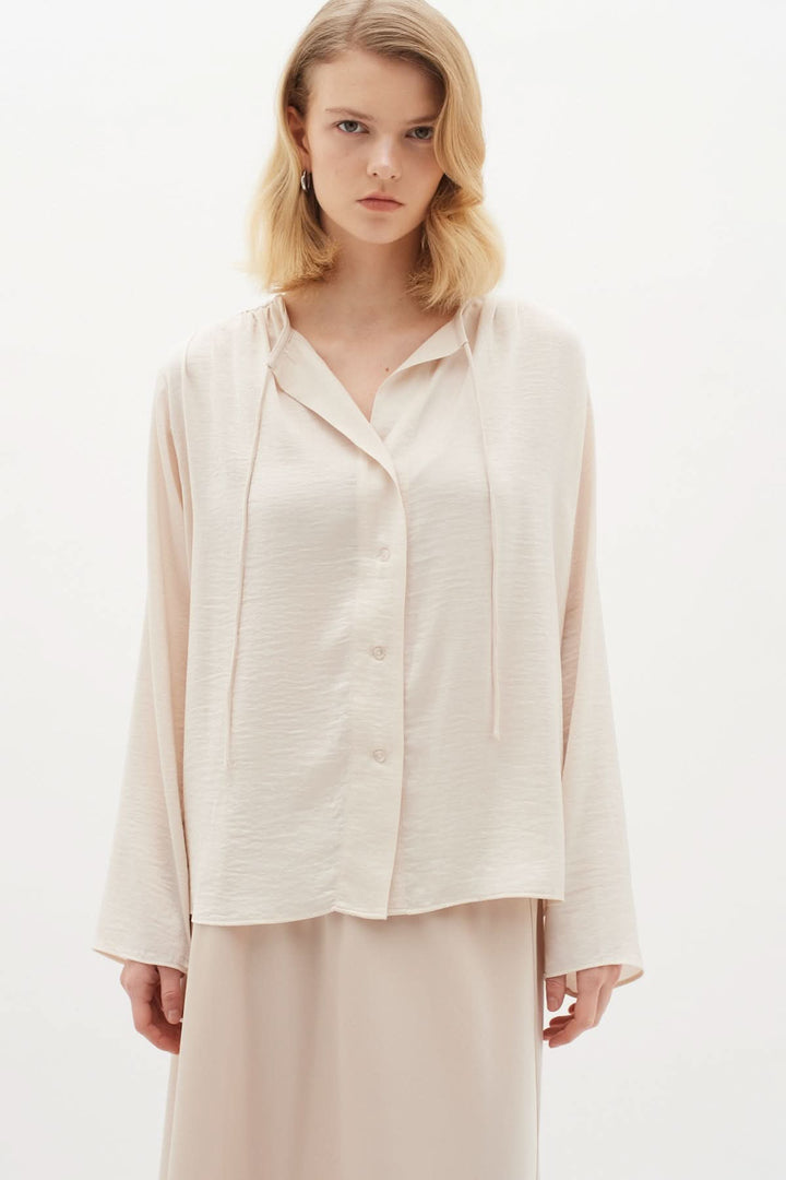 Blouse Mato classique à manches longues et encolure nouée, idéale pour un look chic et élégant.