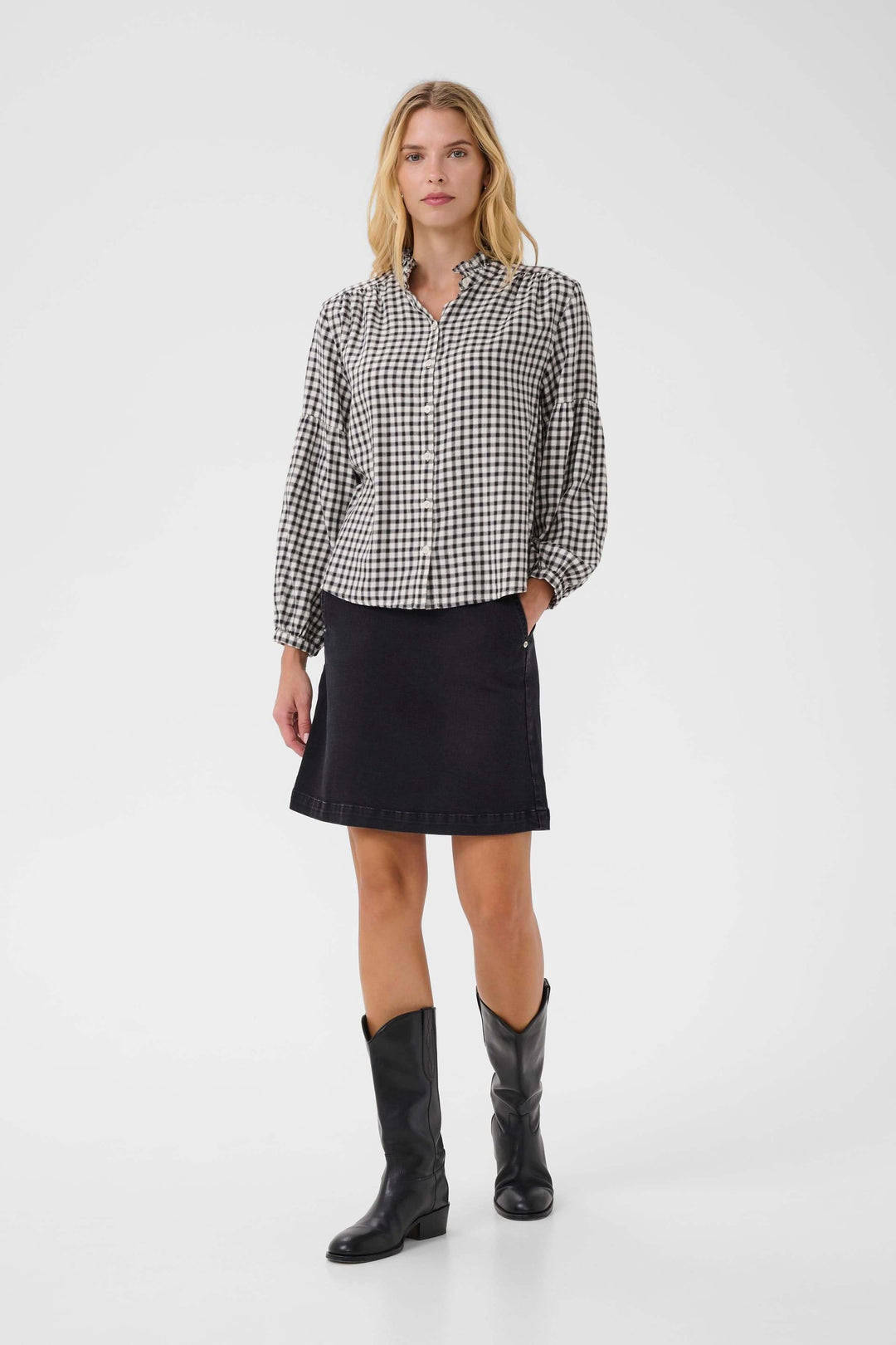 Blouse Samilla à carreaux avec col volanté et manches bouffantes portée avec jupe noire, style chic et intemporel.