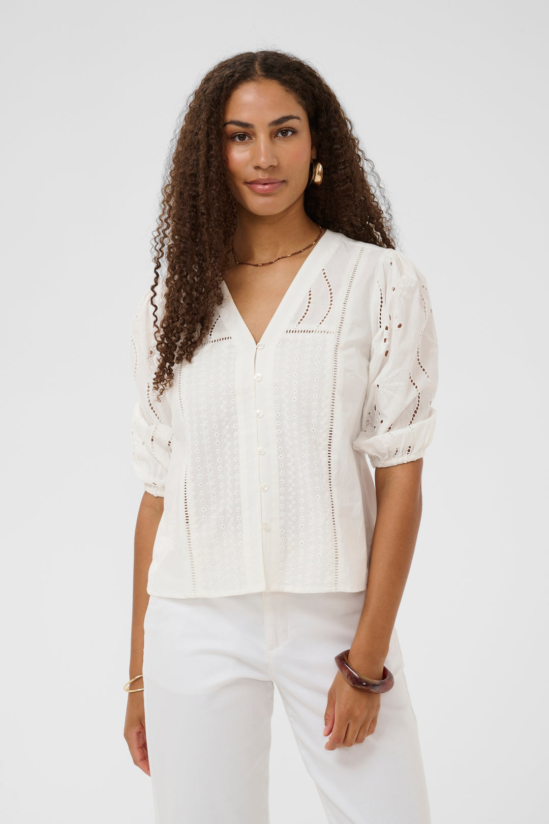 Blouse Signe avec détails ajourés et broderies raffinées, encolure en V, élégance et confort pour un look féminin et sophistiqué.