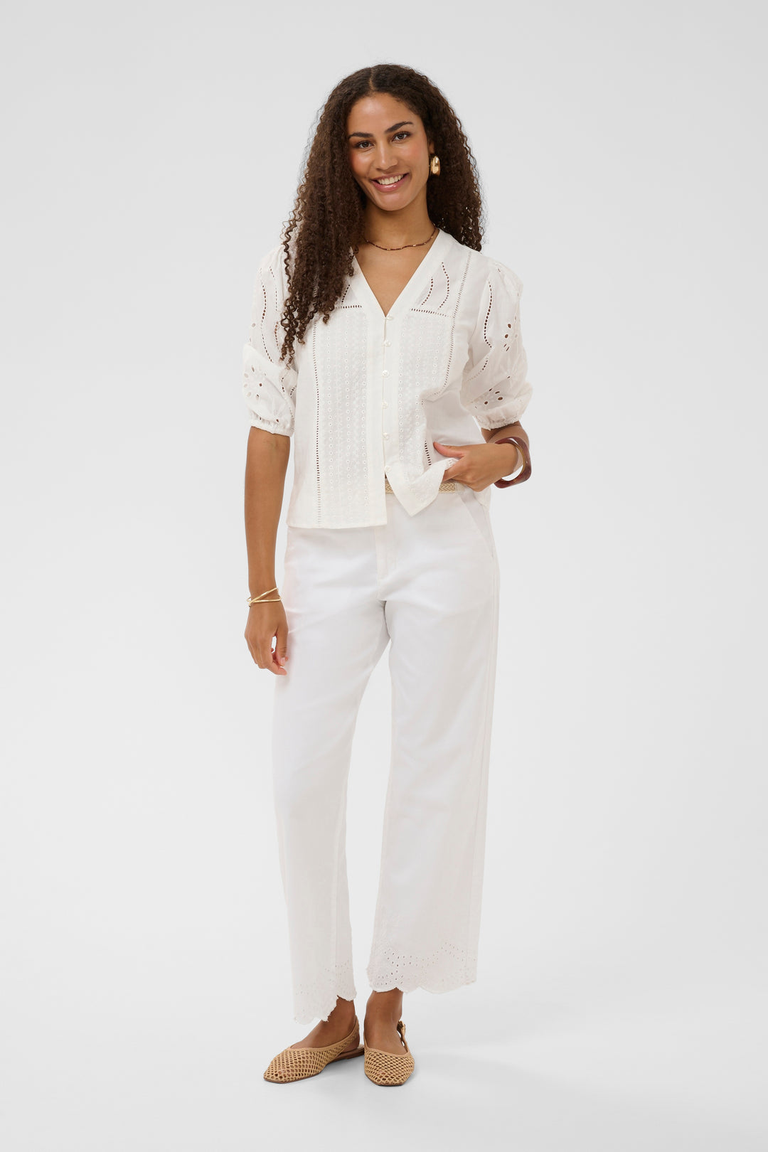 Blouse Signe en dentelle avec encolure en V, portée par un modèle, idéale pour un look élégant et féminin.