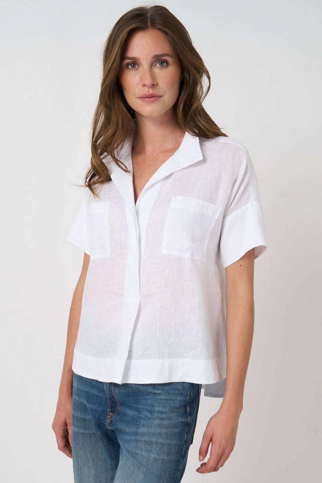 Femme portant une blouse en lin à manches chauve-souris, coupe ample et fluide pour un look estival élégant et décontracté.