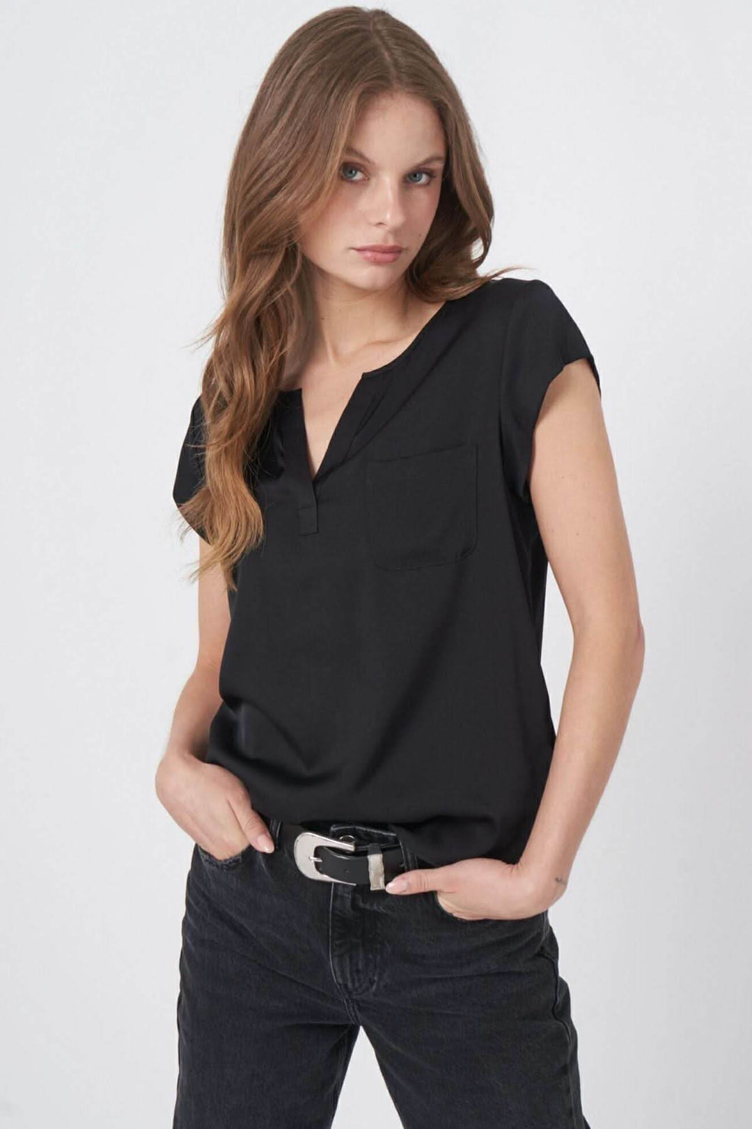 Blouse en soie noire légère avec décolleté en V et mancherons, portée par une mannequin.