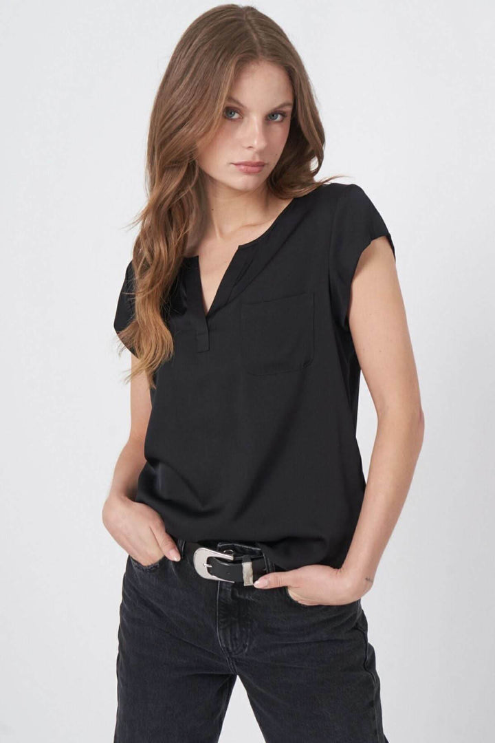 Blouse en soie noire légère avec décolleté en V et mancherons, portée par une mannequin.