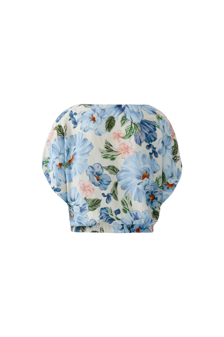 Blouse fluide à manches courtes avec motif floral bleu pour un look élégant et féminin.
