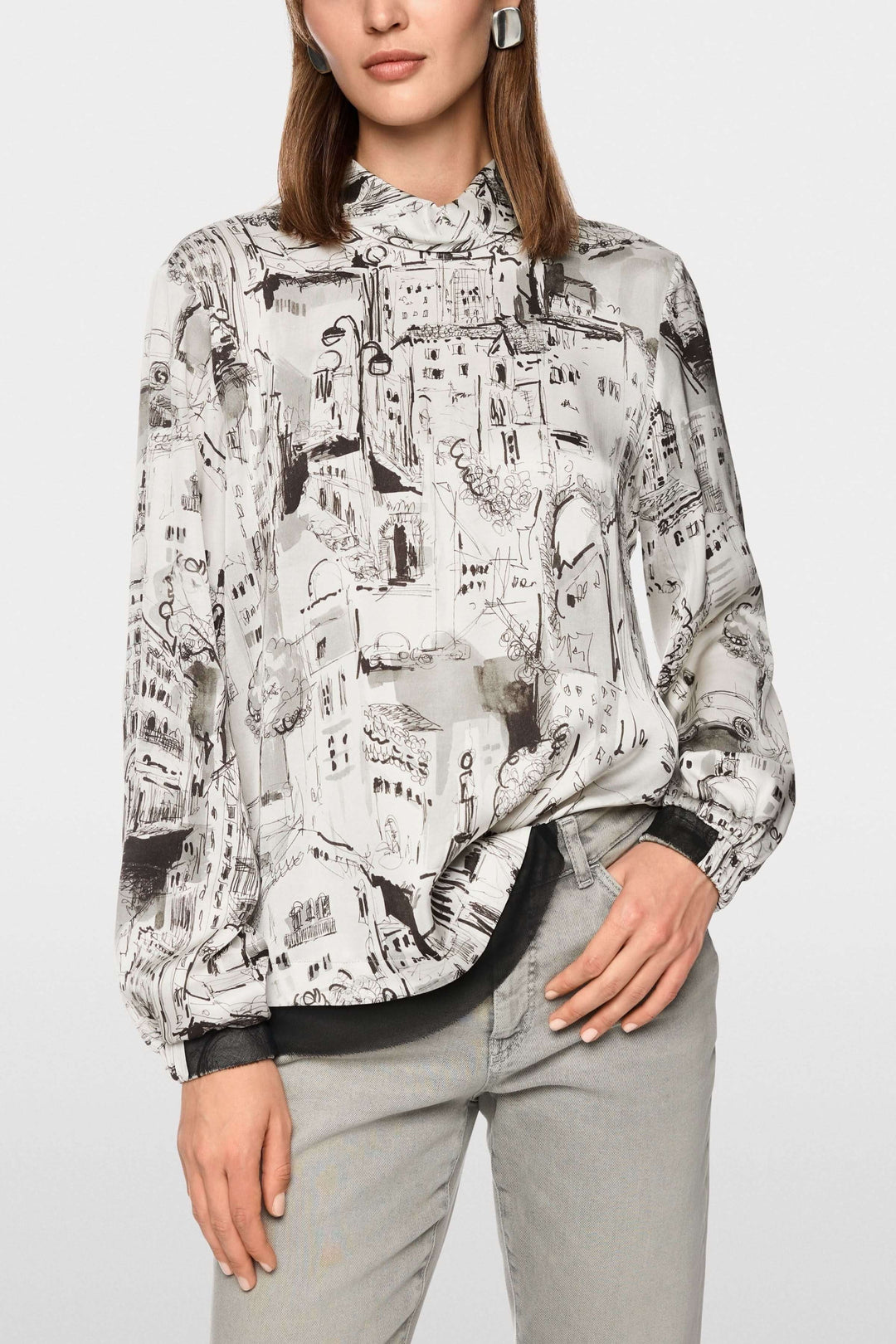 Femme portant une Blouse à imprimé CITY avec manches longues, motif urbain artistique, col montant, idéale pour un look élégant.