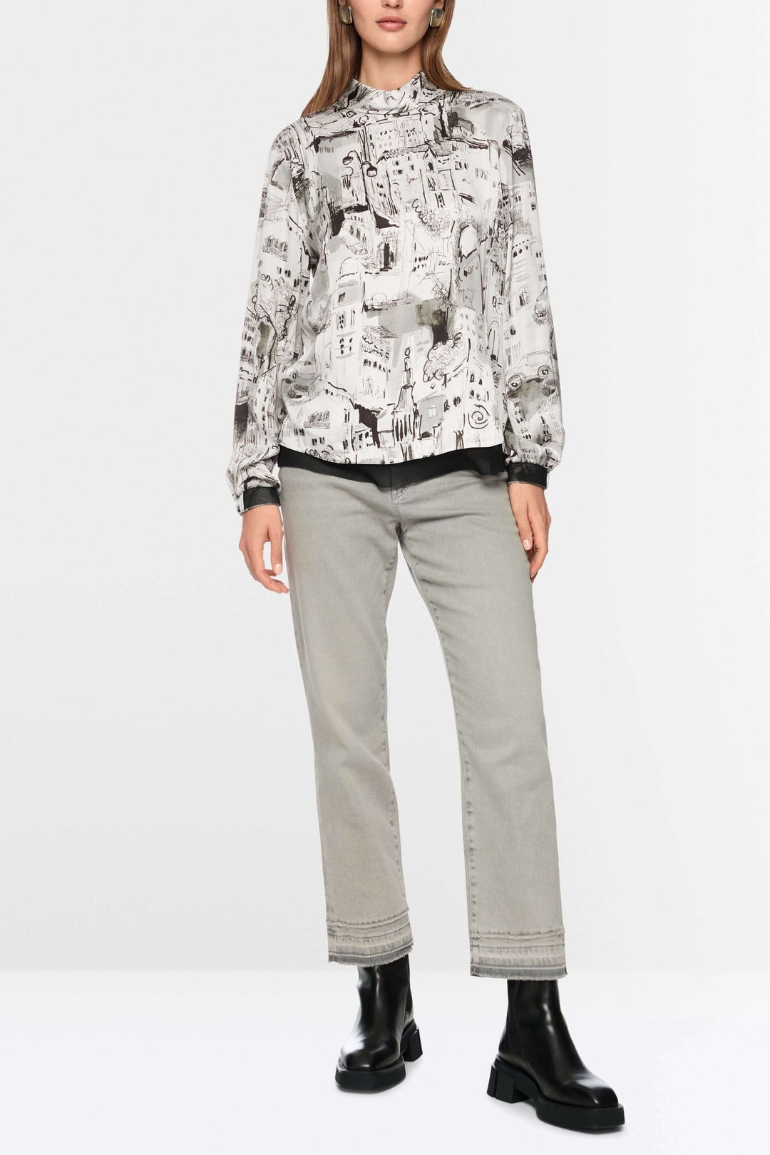 Blouse à imprimé CITY avec motif artistique urbain et manches longues, portée avec jean et bottines noires pour un style élégant.