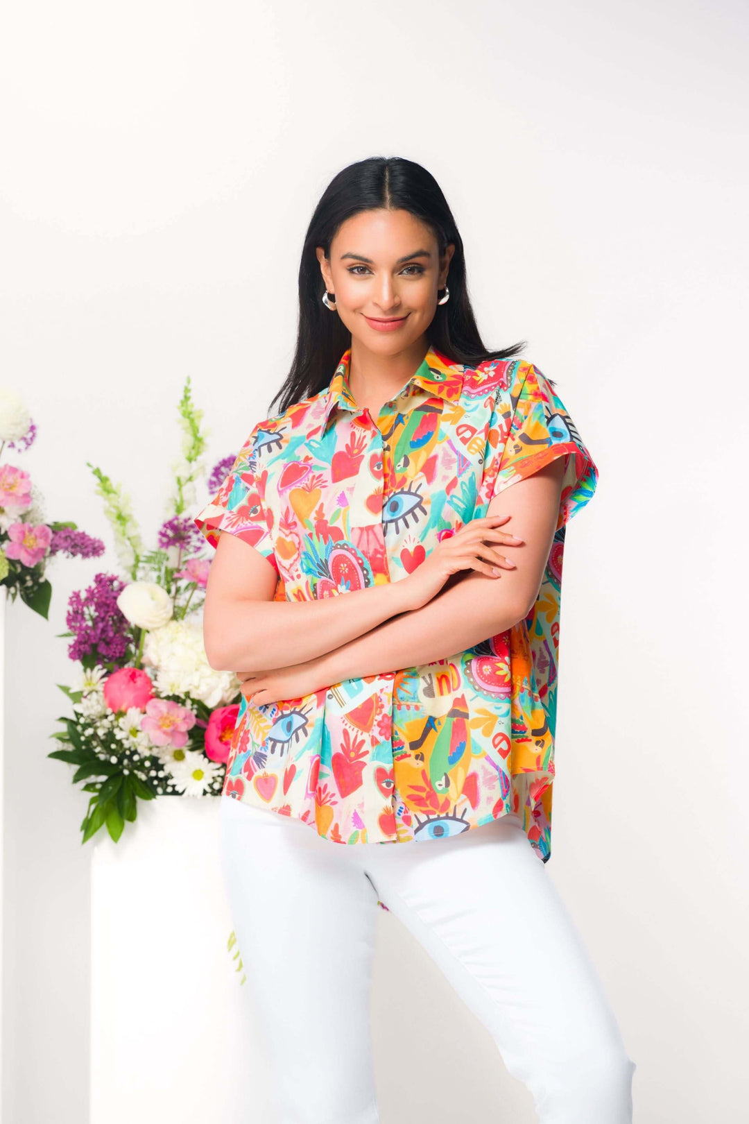 Blouse imprimée à manches courtes avec imprimé expressif et coupe fluide, idéale pour le vestiaire estival, portée par une femme souriante.