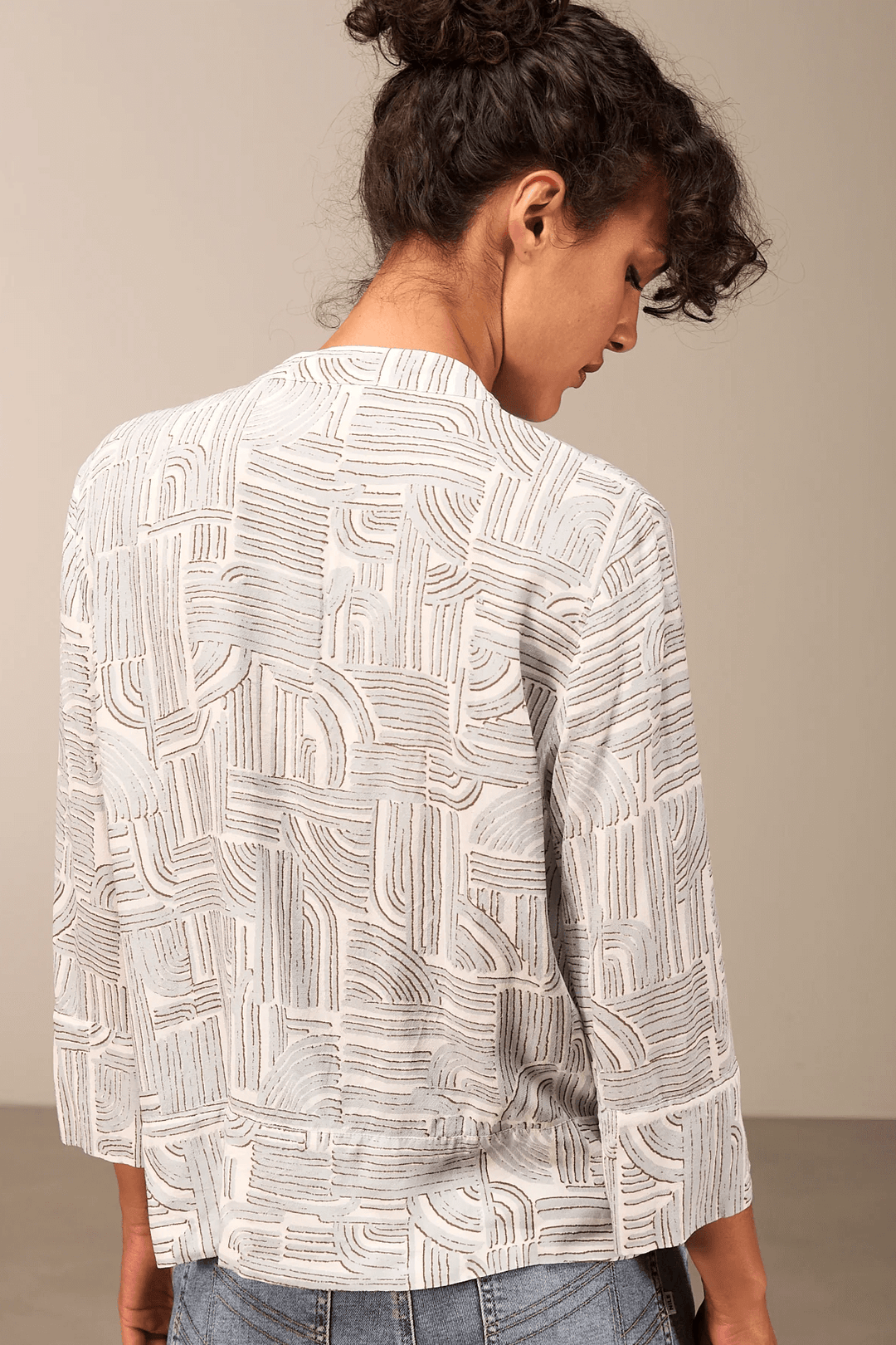 Blouse à manches 3/4 fluide avec motifs abstraits, vue de dos, confectionnée en tissu confortable pour un style moderne et élégant.