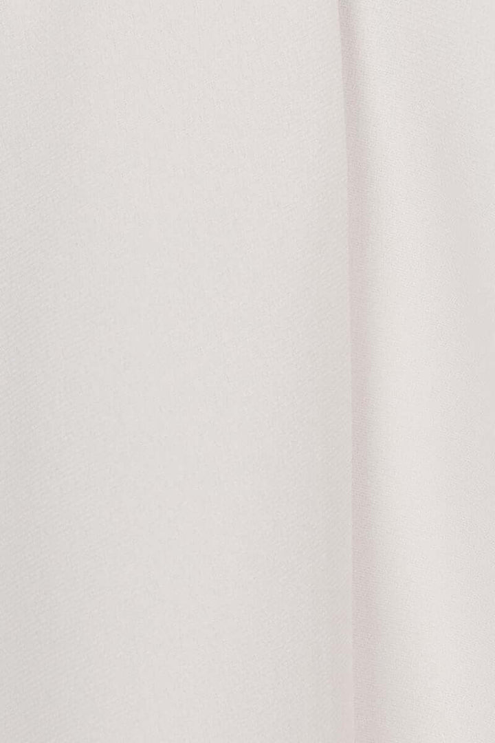 Tissu fluide de blouse à manches courtes, couleur rose pâle, présentant une texture douce et légère.