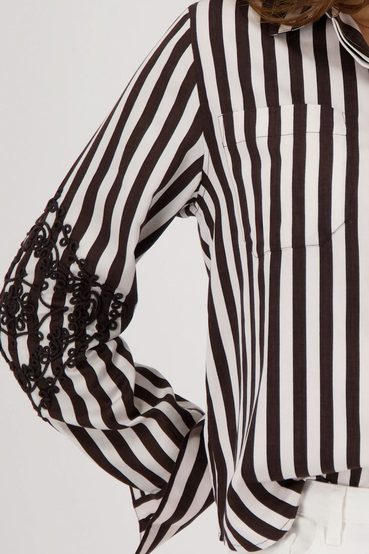 Blouse rayée avec broderies aux manches, motif graphique, contrastes élégants et coupe fluide pour confort au bureau et décontracté.