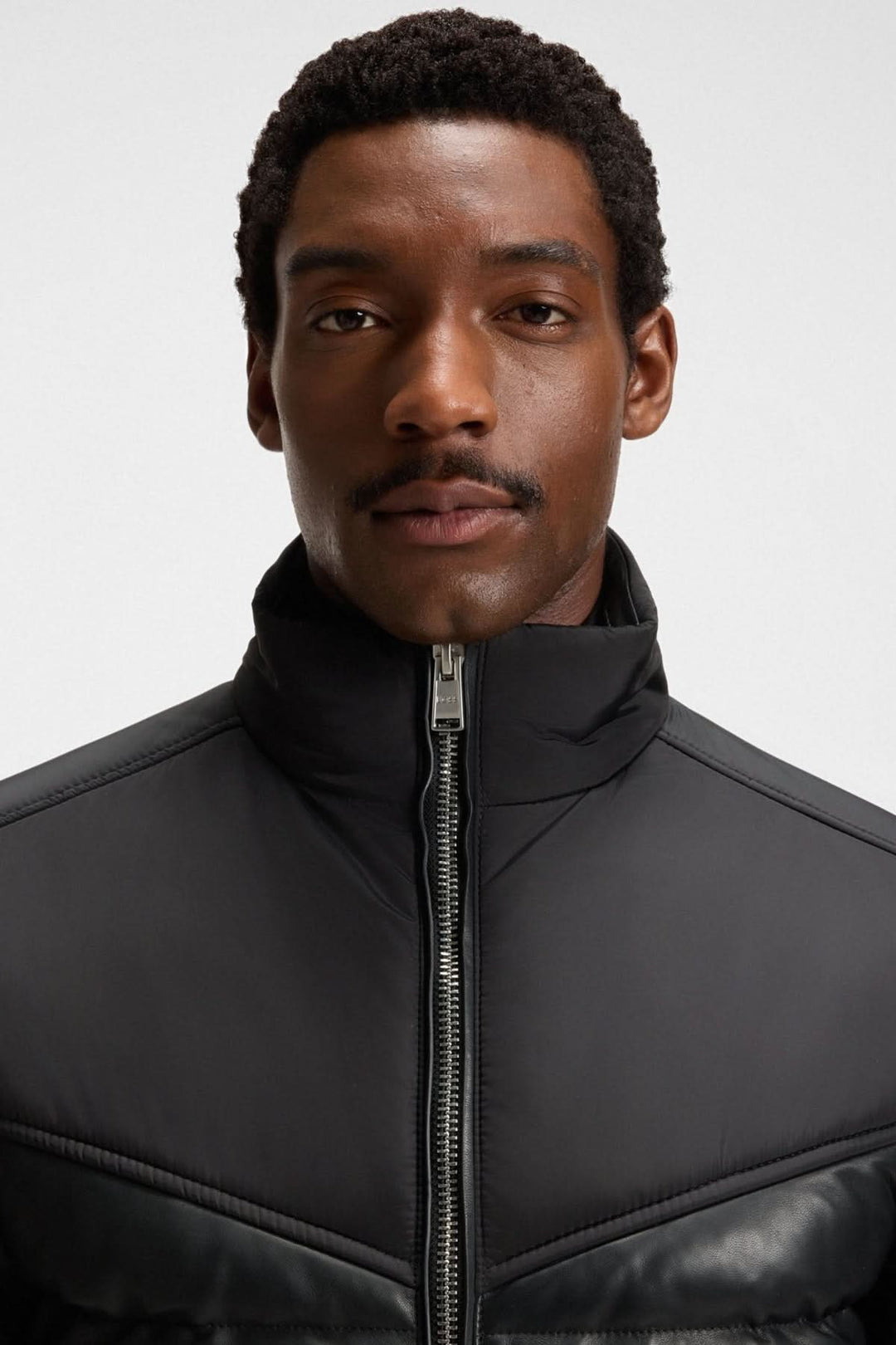 Homme portant un blouson en cuir d’agneau avec col montant et finitions côtelées, style moderne et élégant.