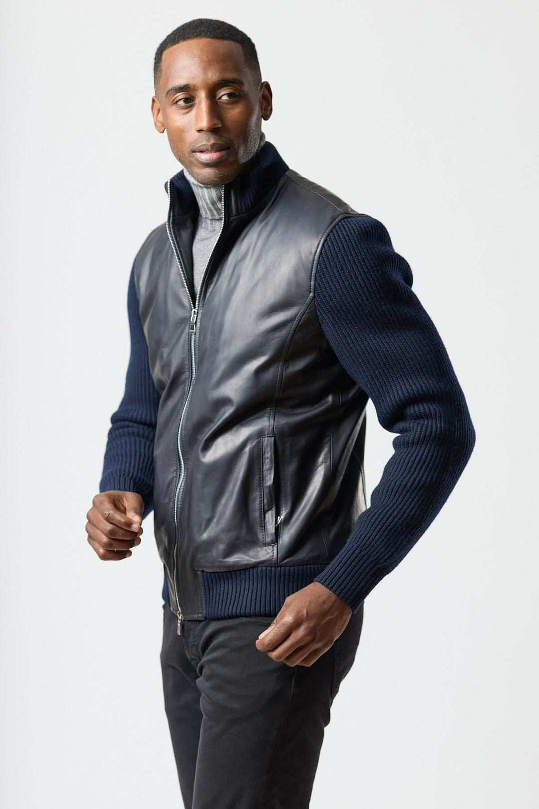 Blouson hybride cuir &amp; tricot zippé moderne porté par un homme élégant avec col roulé, offrant confort et style urbain.