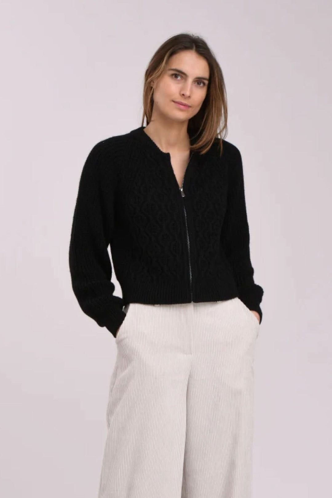 Cardigan noir texturé avec fermeture éclair, coupe décontractée, idéal pour un look chic et moderne.