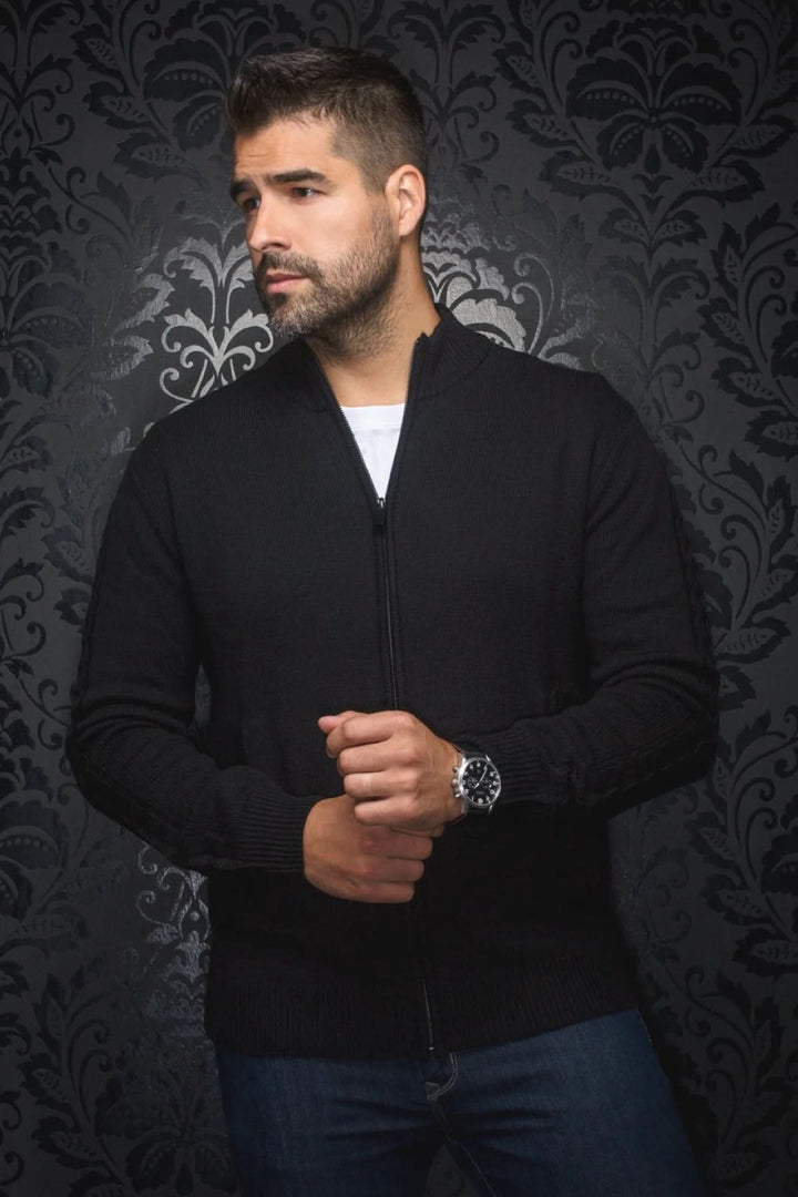 Chandail noir en laine Esteban, homme stylé avec fermeture éclair, contre un fond décoratif.