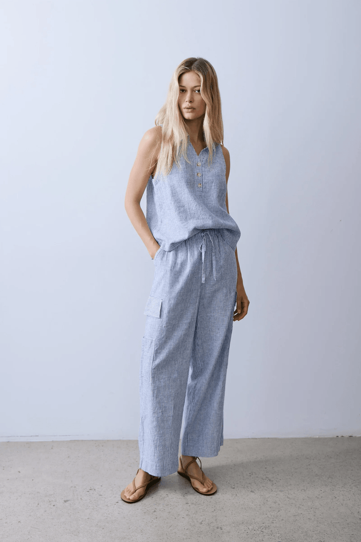 Femme portant une Camisole Bassin rayée à col chemise avec un pantalon ample en tissu léger.