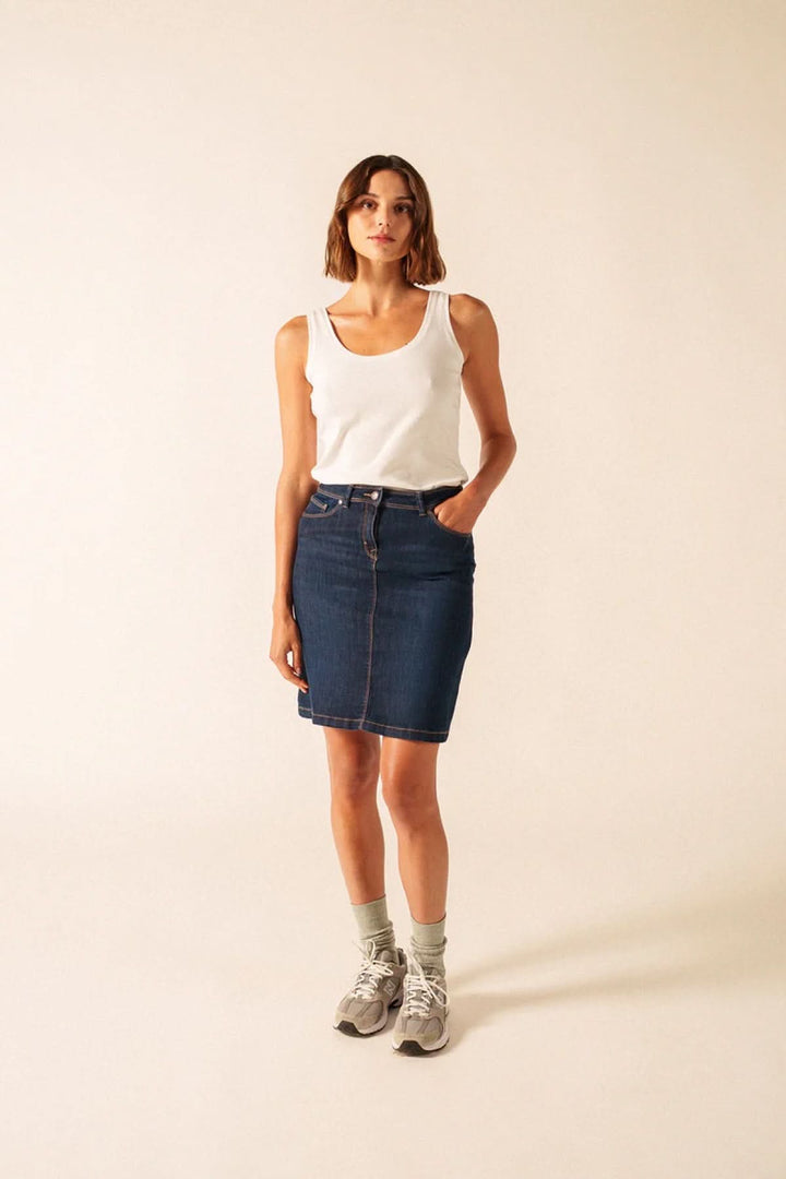 Femme portant une Camisole Bastia blanche avec jupe en jean.