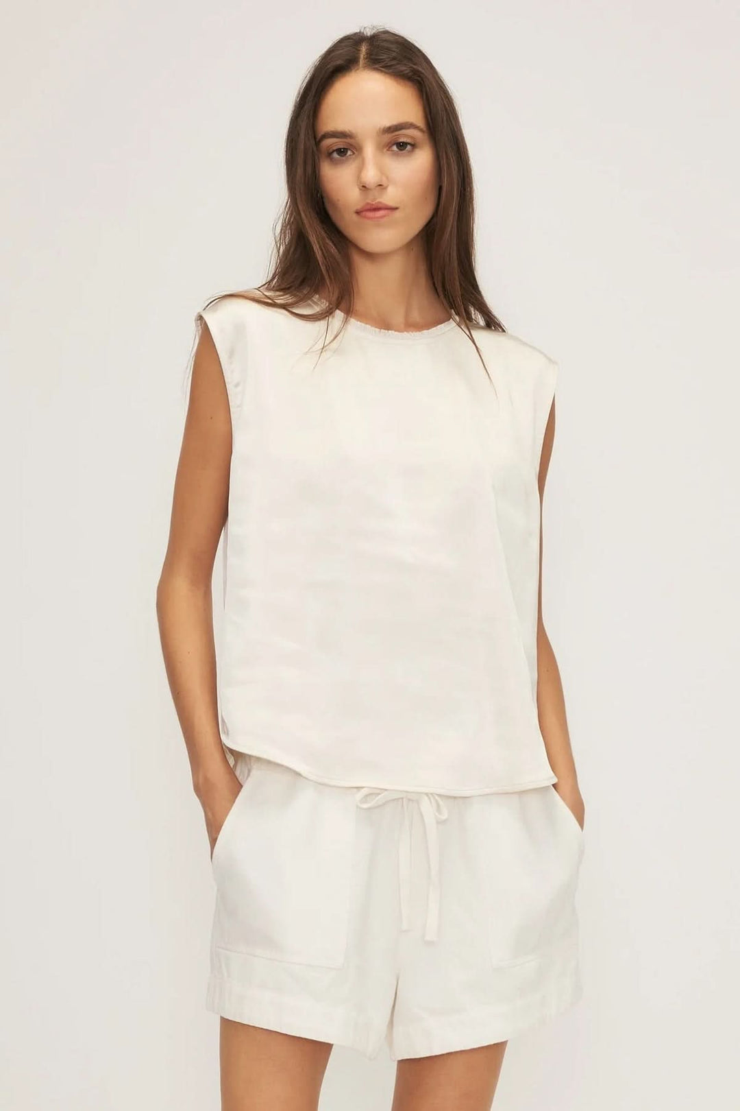 Camisole satinée Celia en ivoire avec épaules légèrement étendues, coupe droite, et tissu doux.