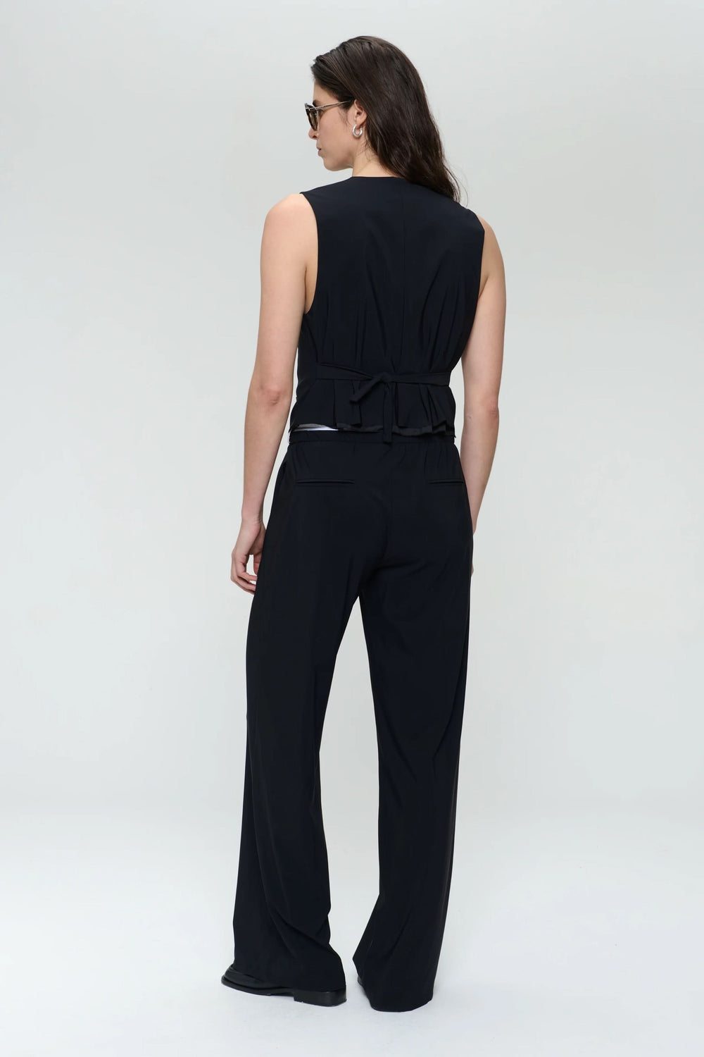 Camisole sans manches noire avec col en V, silhouette ajustée et détails contemporains, vue de dos.