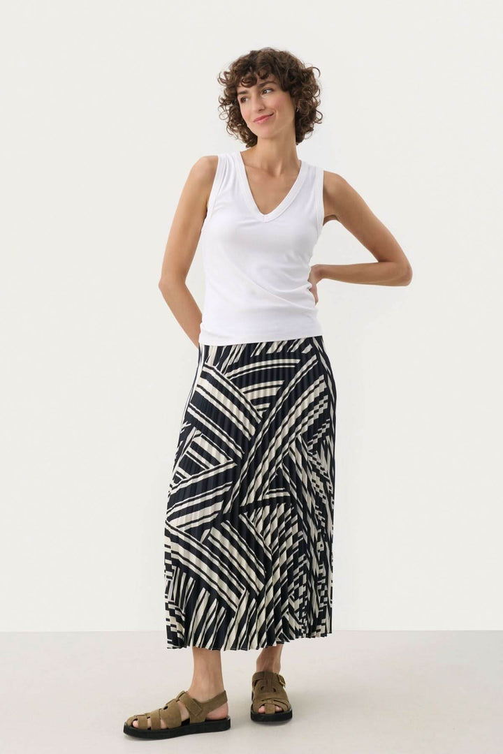Camisole Nikkia en viscose, col en V, portée avec une jupe à motifs, look décontracté élégant.