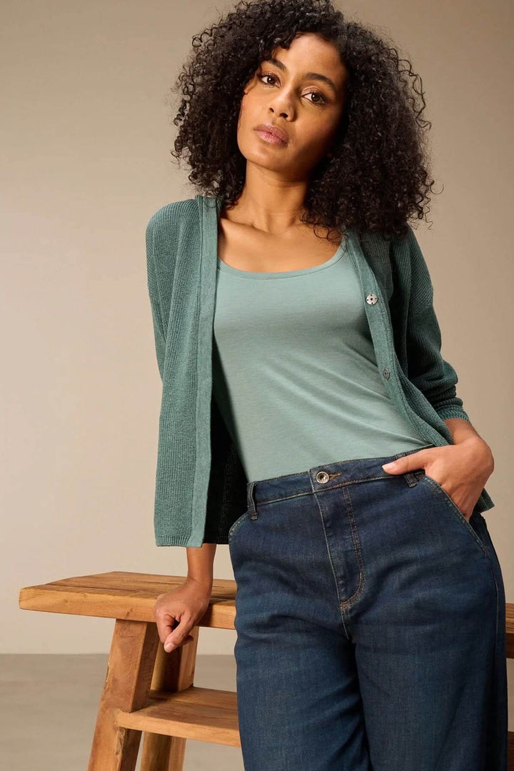 Femme portant une camisole à col rond avec un cardigan et un jean, mise en valeur de la coupe ajustée et de l&