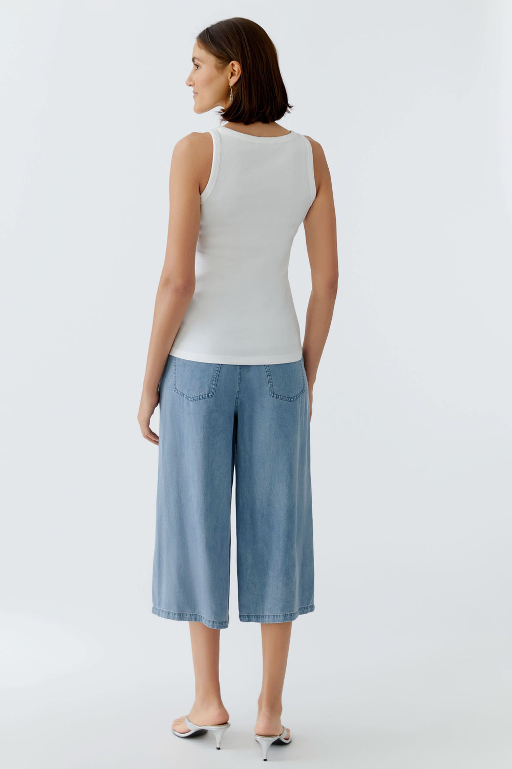 Vue arrière de la camisole côtelée avec inscription brodée portée avec un jean large. Décris moi le produit en français.