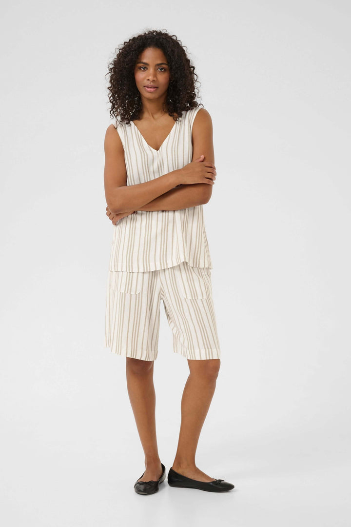 Femme portant une camisole sans manches rayée à col en V et un short assorti, pour un style décontracté.