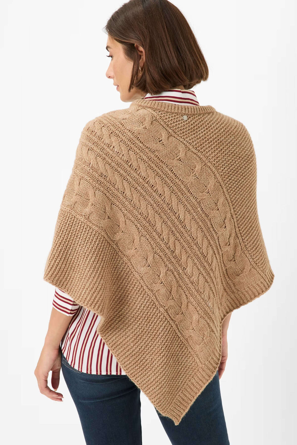 Cape Thea en tricot torsadé avec motif texturé, coupe asymétrique, portée par une femme, style élégant pour la mi-saison.