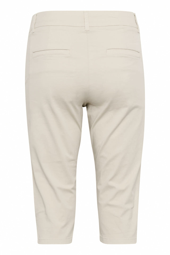 Ce capri ajusté beige, avec poches arrière, est parfait pour les journées estivales, offrant confort et style.