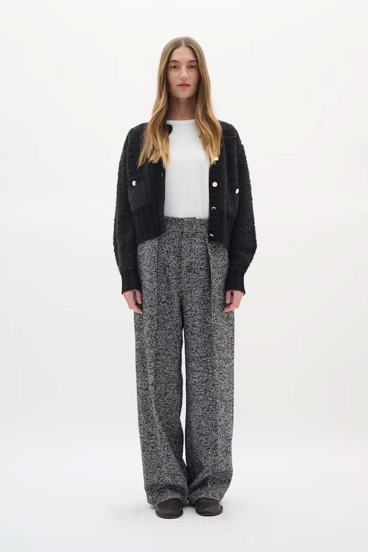 Cardigan Guo moderne avec boutons dorés et maille texturée, porté avec pantalon taille haute, style sophistiqué et chic.