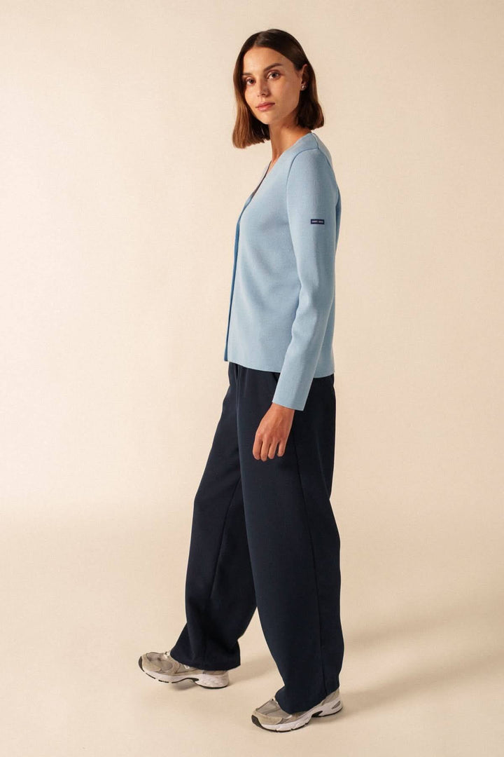Femme portant un cardigan de laine BREVANDS bleu avec un pantalon ample.