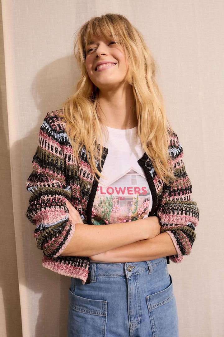 Femme portant un cardigan en maille texturée avec motif graphique, coupe droite et encolure ronde, style décontracté.