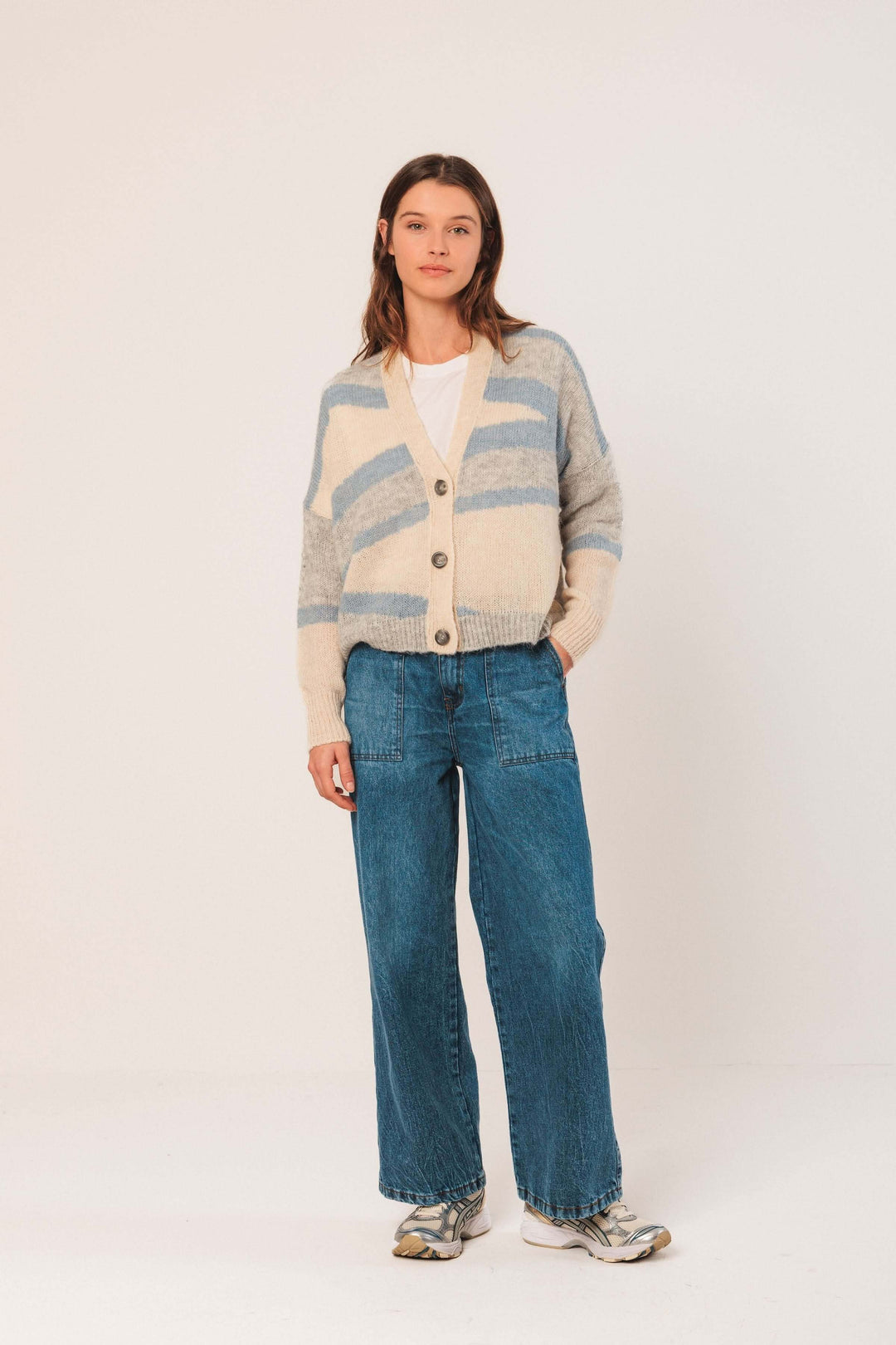 Cardigan en maille douce avec motif graphique, encolure en V et boutons, porté avec jean large.