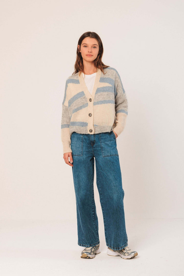 Cardigan en maille douce avec motif graphique, encolure en V et boutons, porté avec jean large.