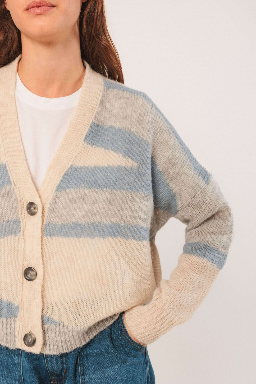 Cardigan en maille douce avec un motif graphique en beige et bleu, encolure en V et gros boutons.