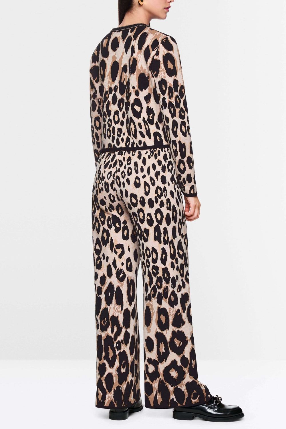 Cardigan léopard à motif animal, coupe droite élégante, porté avec pantalon assorti, look moderne et audacieux.