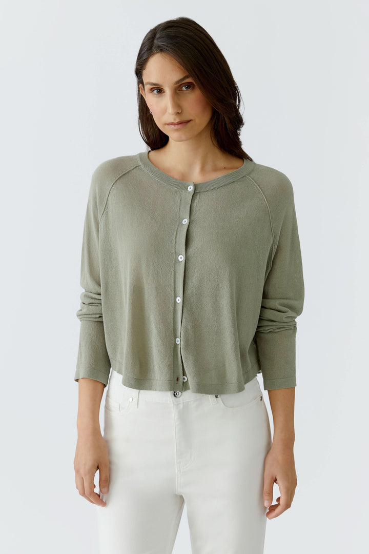 Femme portant un cardigan texturé boutonné élégant et féminin, texture subtile en relief, pour un look polyvalent et confortable.