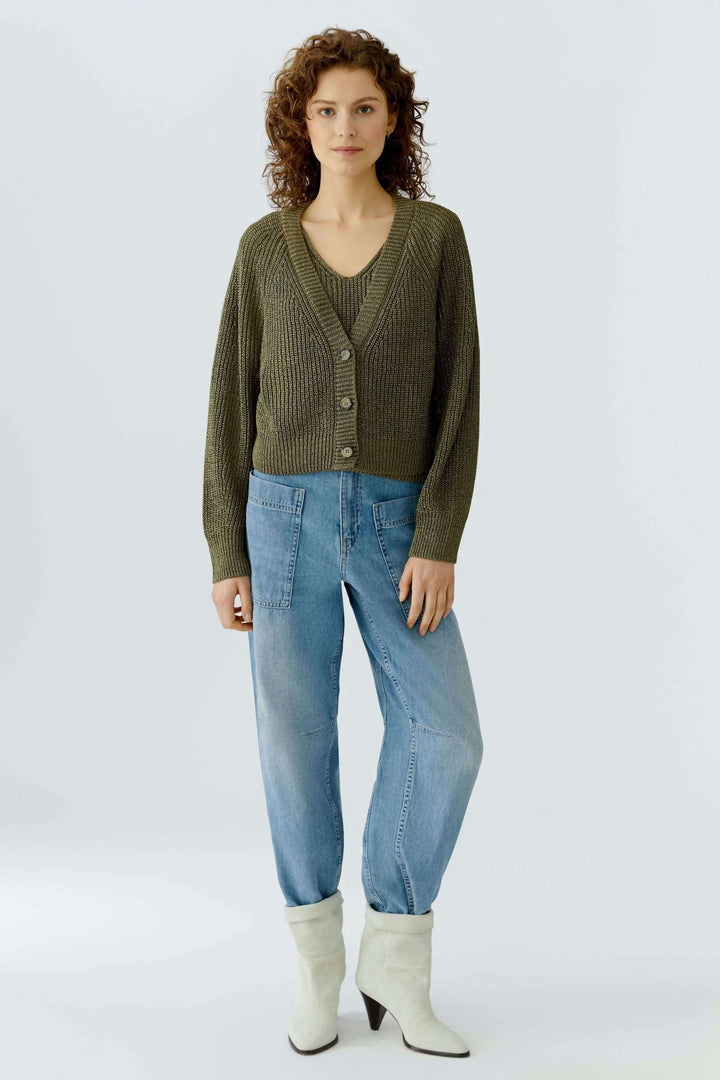 Cardigan tricoté court avec encolure en V et boutons classiques porté par-dessus un haut léger, confortable et essentiel du quotidien.