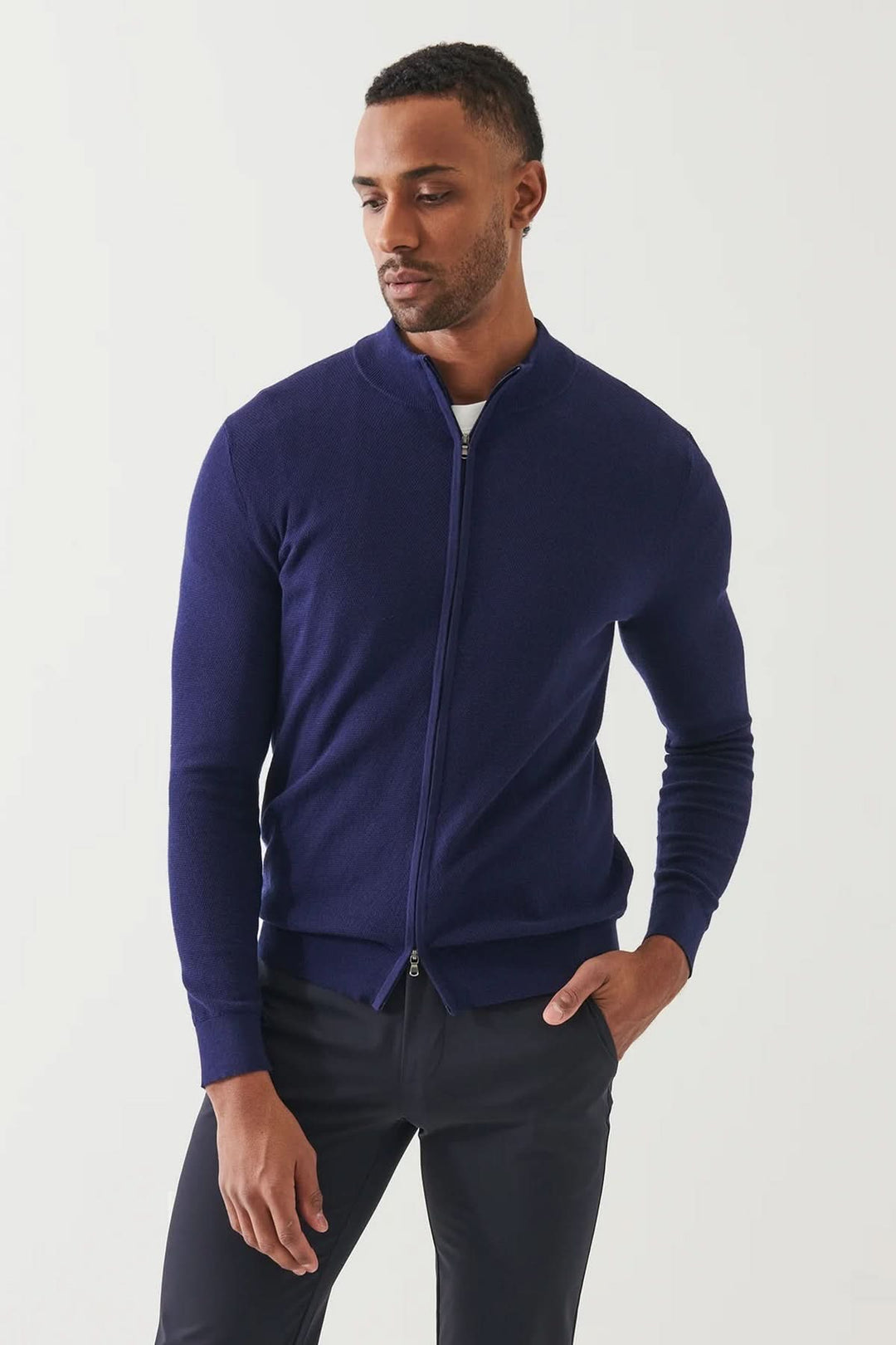 Cardigan zippé en coton et cachemire, couleur bleu marine, alliant élégance et confort, porté par un homme.