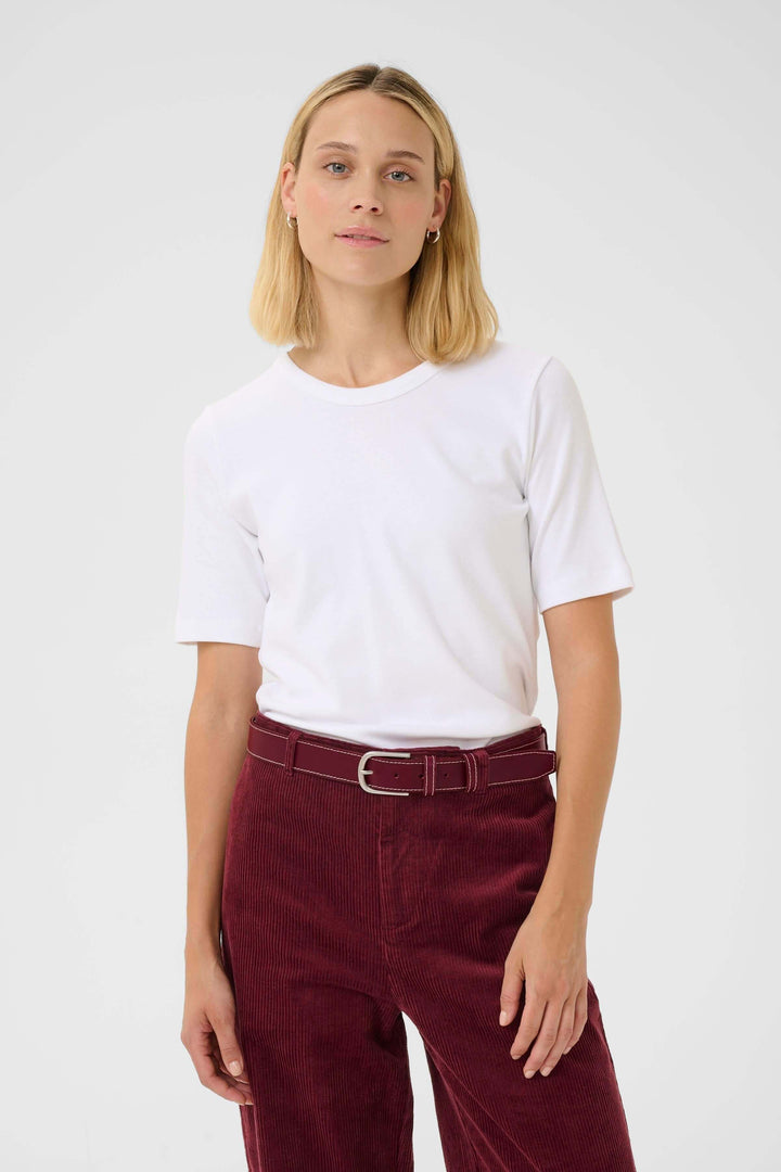 Femme portant une Ceinture Seyra en cuir véritable avec boucle métallique et surpiqûres contrastantes, idéale pour un style sobre et chic.
